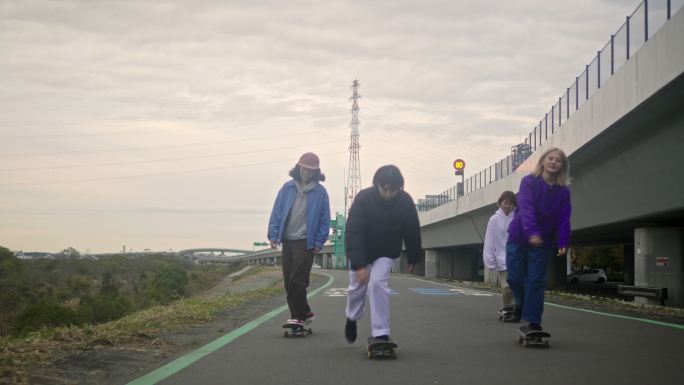年轻的日本女子滑板运动员在路上骑行