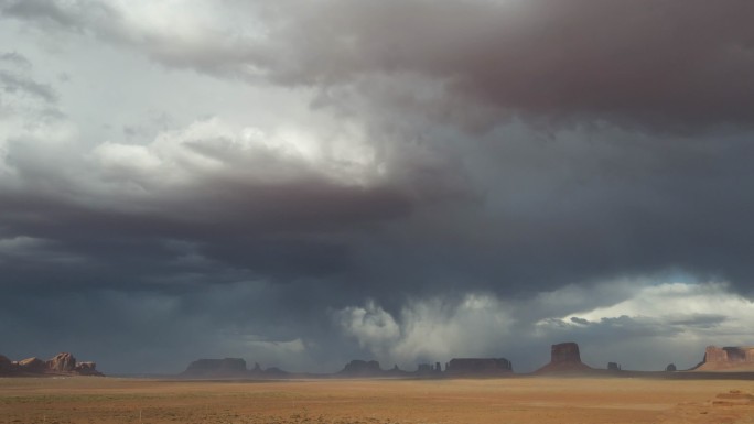 亚利桑那州纳贾沃部落公园纪念碑谷的梅里克·巴特和米滕斯在戏剧性的天空和狂风沙尘暴下俯瞰超时空