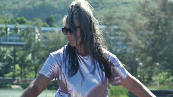 在阳光明媚的日子里，戴着墨镜、头发花白的53岁的拉丁美洲和西班牙裔高级运动女性玩滑板的快乐。运动概念
