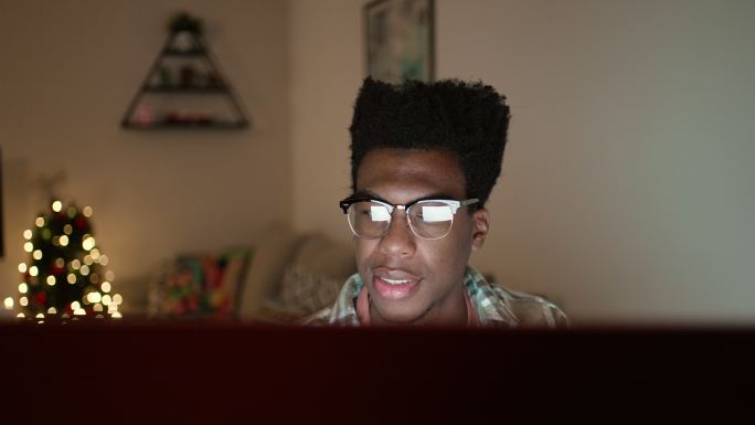 一名男子深夜使用电脑进行网上圣诞购物的特写镜头