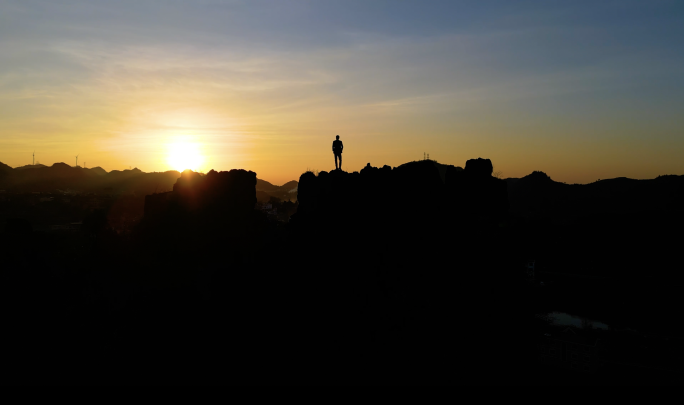 意境商务男士站在山顶上看美丽日落背影剪影