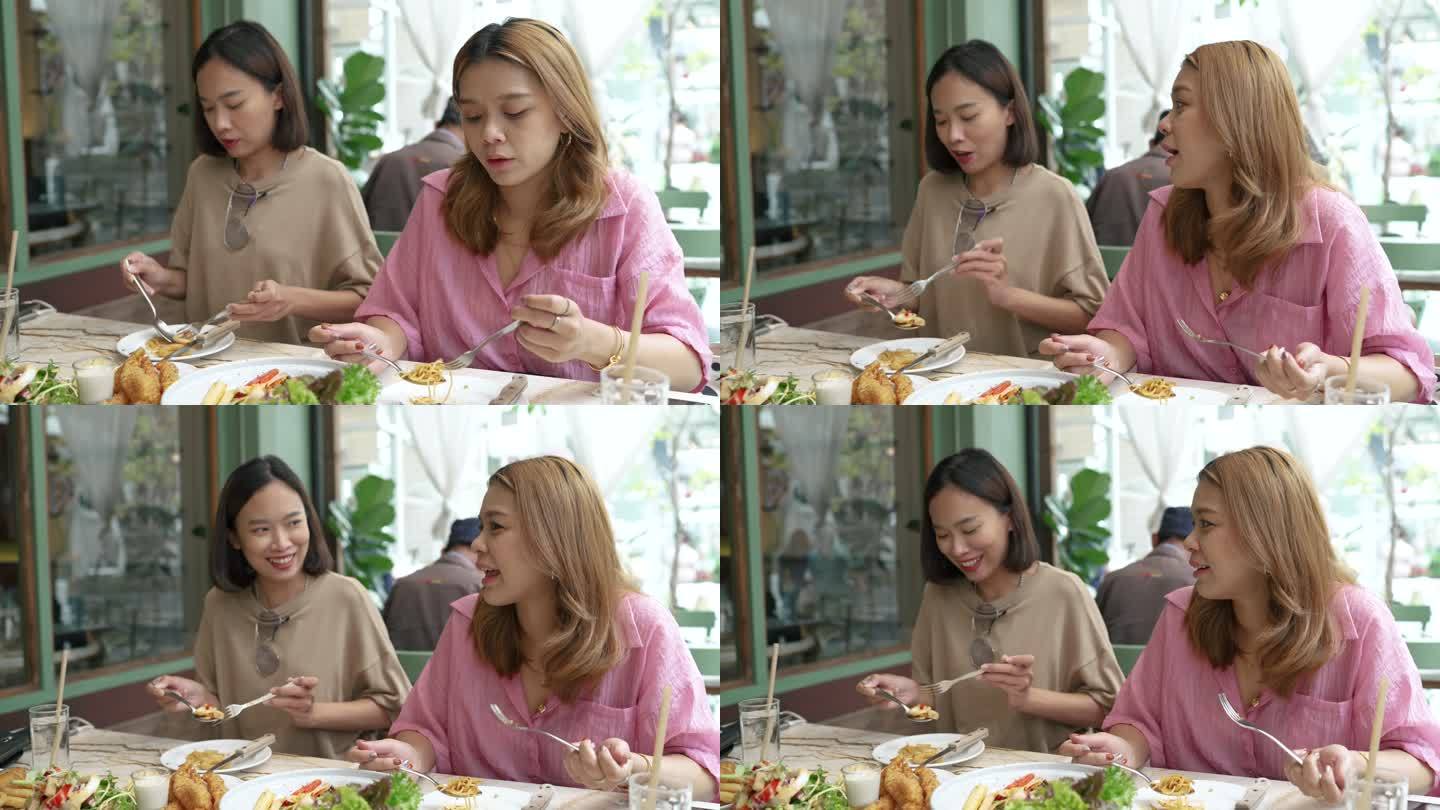 两名亚洲女性在当地融合美食餐厅吃午饭。
