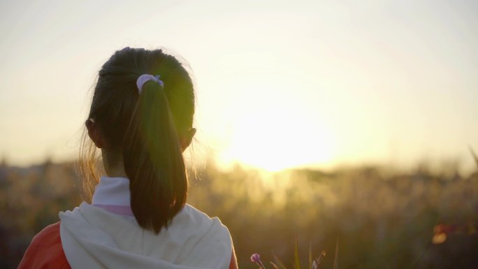 面向太阳挥动双手的女孩