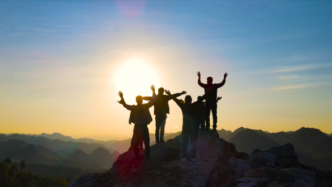 一群人山顶欢呼剪影团队精神攀登顶峰登山者