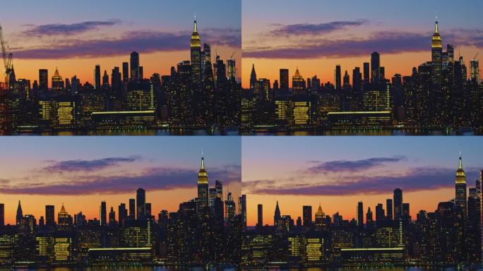 从皇后区鸟瞰曼哈顿中城，俯瞰长岛市海滨的豪华住宅楼，在黄昏的暮色中，天空充满戏剧性的光芒。无人机视频