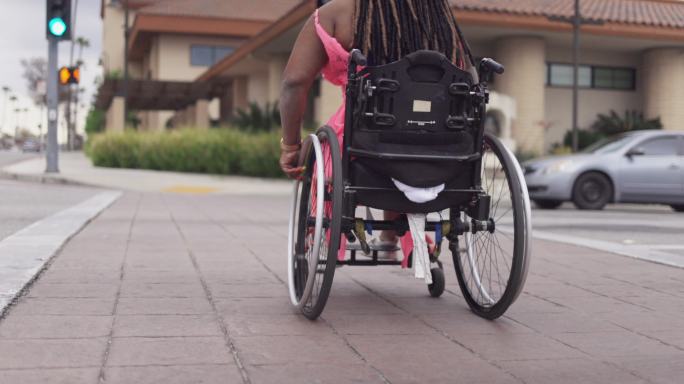 坐在轮椅上移动的黑人残疾妇女