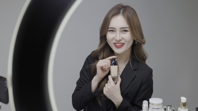 一位身穿黑色西装的韩国美女女主人在网上出售化妆品