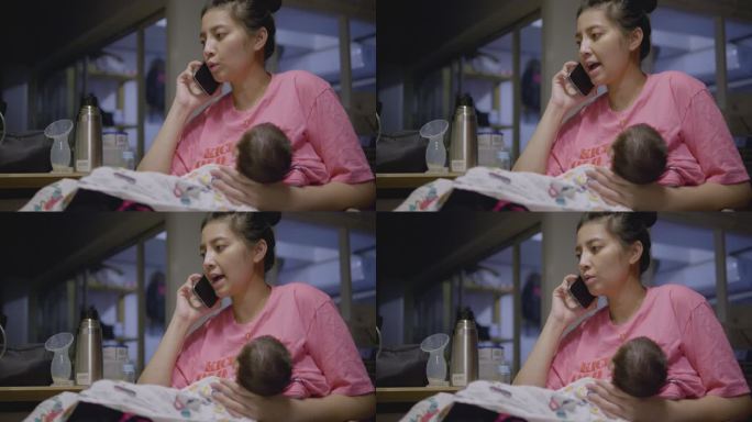 亚洲妈妈深夜在电话里工作，抱着睡着的小儿子。