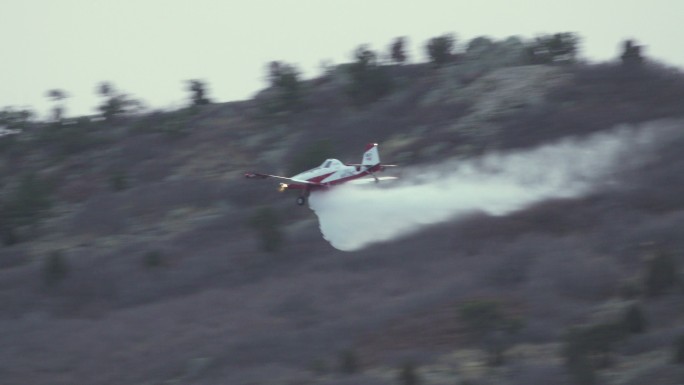 小型消防飞机向冒烟的奥克消防队科罗拉多州利特尔顿山麓洒水