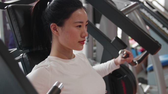 美女健身房锻炼身体力量训练手臂