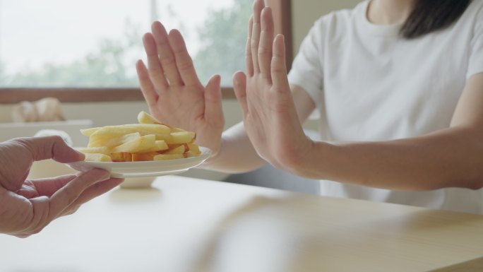 保健妇女用手推炸薯条。拒绝吃面粉和糖。饮食观念