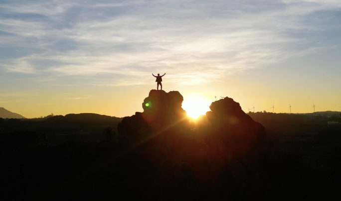 企业家登山日出时男人山顶张开双臂拥抱太阳