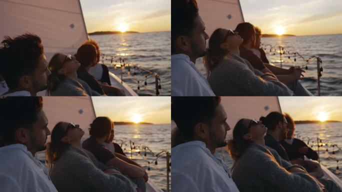 WS日落时分，一群朋友在帆船甲板上享受微风