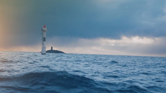 从船上眺望波涛汹涌的大海，在开阔的海洋中有灯塔