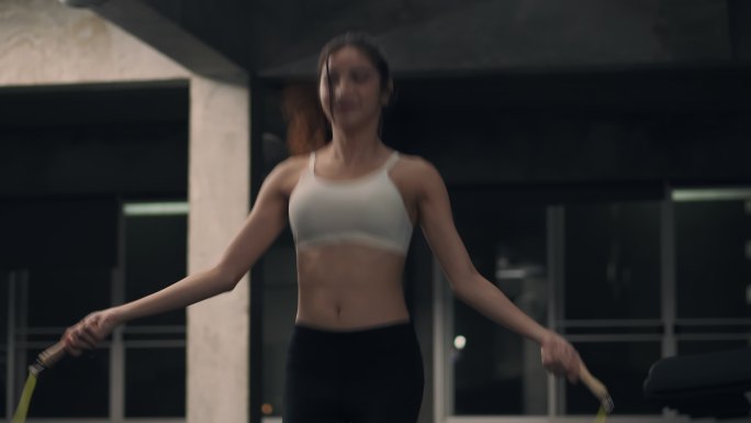 亚洲年轻的女运动员在室内健身房里跳绳，只专注于有氧运动训练。