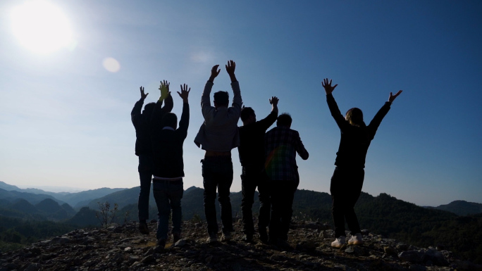 一群青春少年山顶欢呼跳跃背影双手拥抱未来