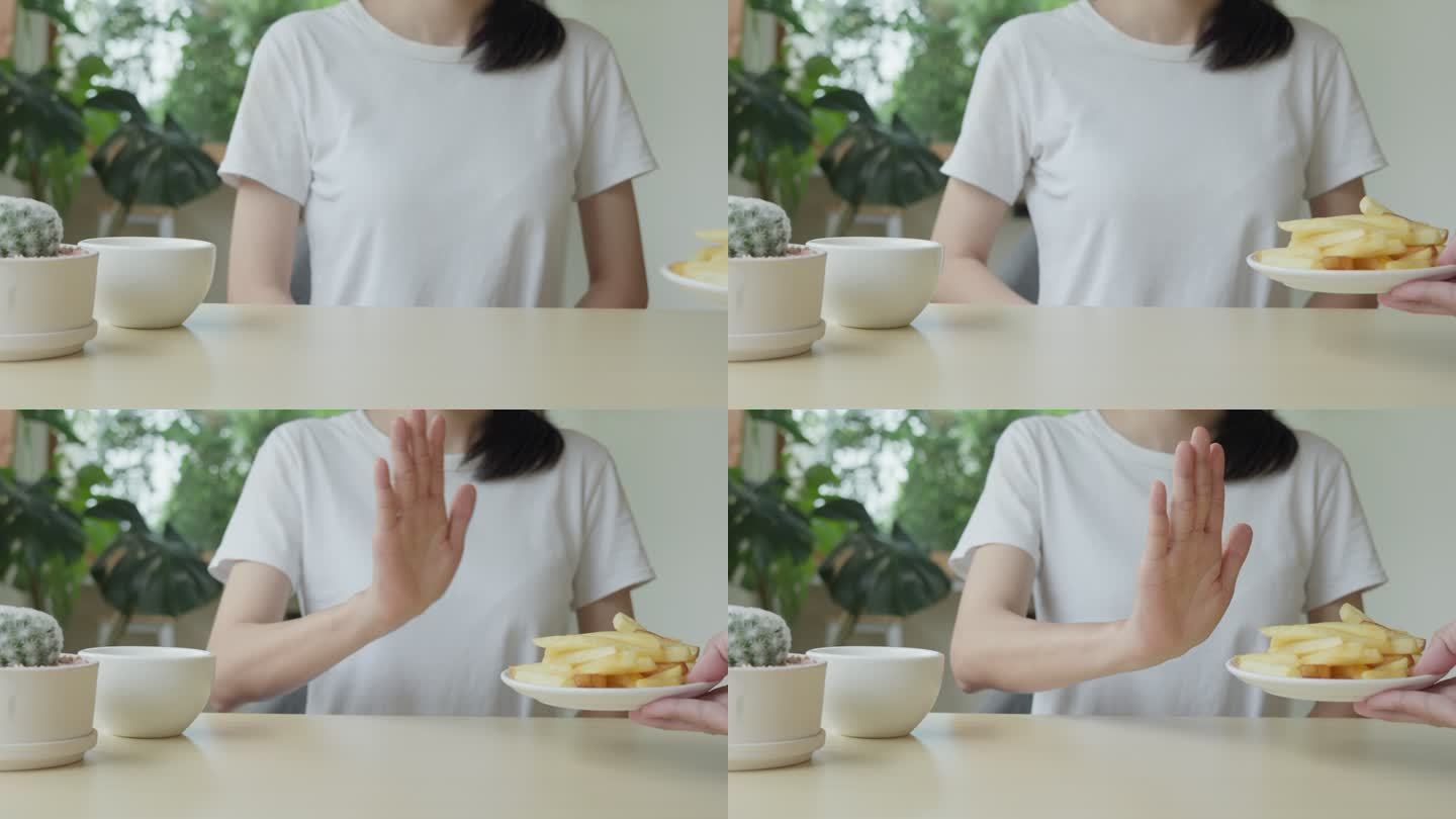 其中一名保健女孩用手推了一盘薯条。拒绝食用含有反式脂肪的食物。