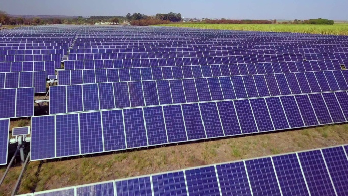 航拍数百个太阳能模块或成行的太阳能电池板，覆盖大片区域，用于清洁能源发电。无人机视角