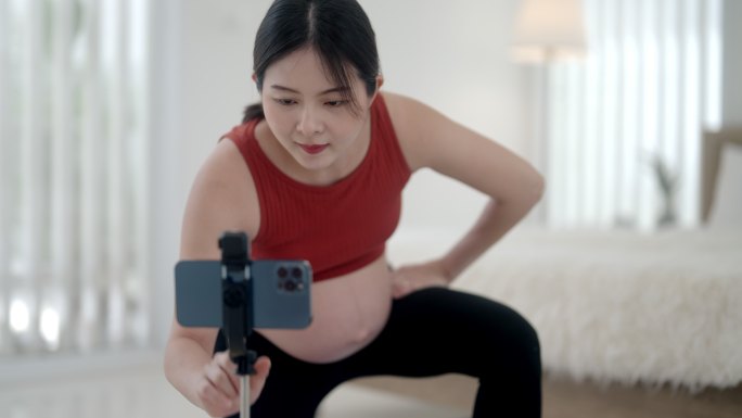 孕妇握紧肌肉孕妇看手机瑜伽运动