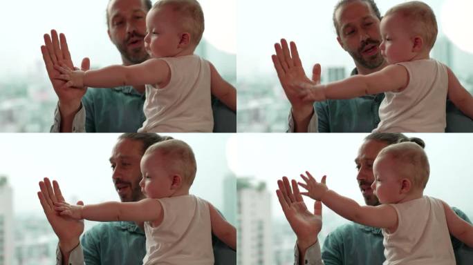 一名男婴正在抚摸父亲的手，也称为击掌。一位父亲正在和儿子可爱地玩耍，表明父亲和孩子的关系。