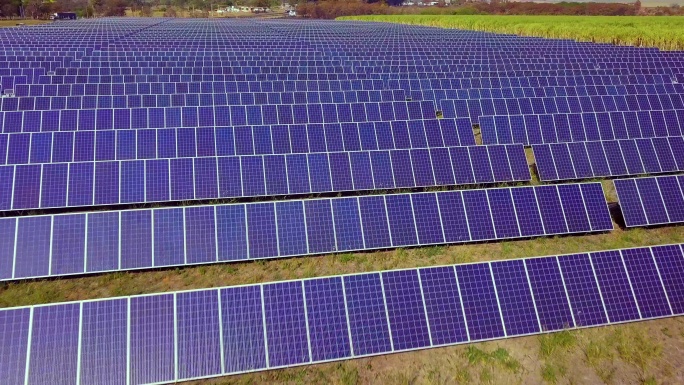 航拍数百个太阳能模块或成行的太阳能电池板，覆盖大片区域，用于清洁能源发电。无人机视角