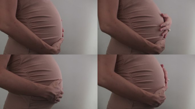 亚洲孕妇用手触摸和抚摸孕妇的肚子