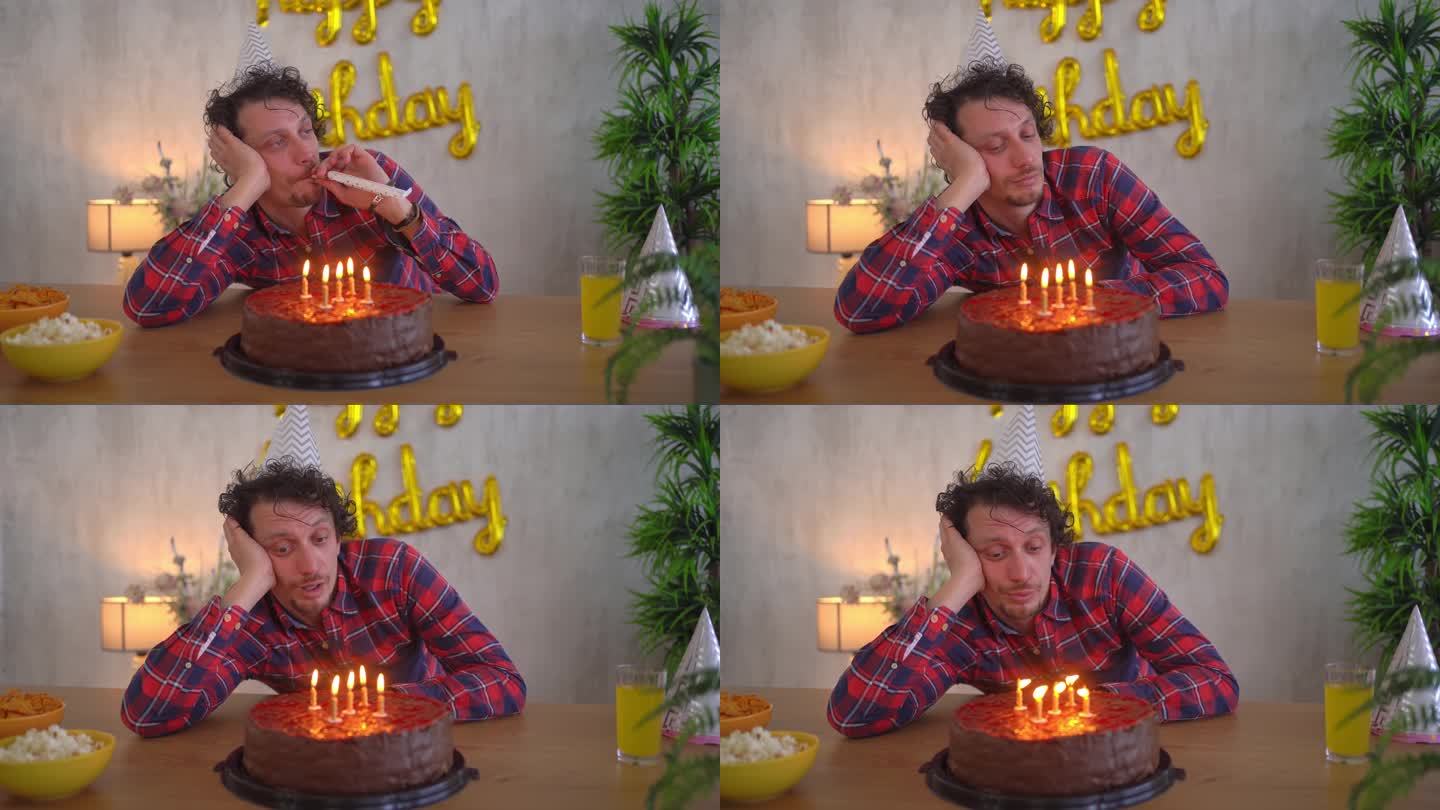 年轻悲伤的男人独自用生日蛋糕庆祝生日