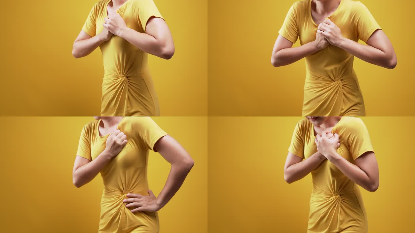 女性胸部疼痛在黄色背景下孤立
