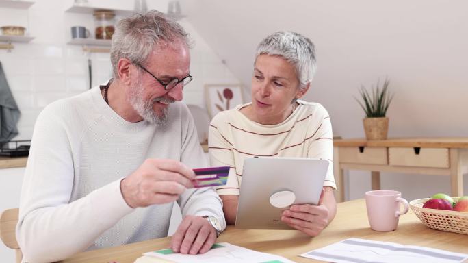 老年夫妇在网上银行理财，并在家管理每月开支