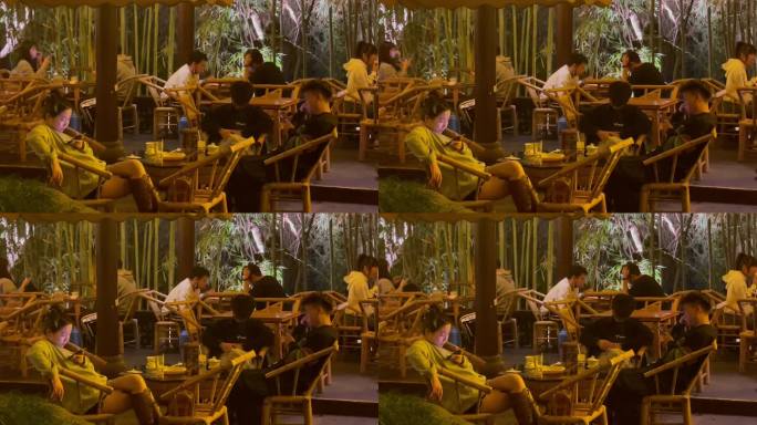 夜晚公园竹编椅喝盖碗茶玩手机的人们2