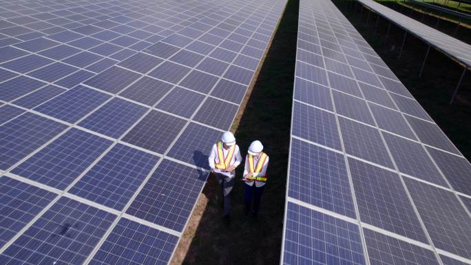 鸟瞰太阳能电池技术工程师，检查太阳能农场的太阳能电池板。