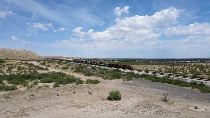 在圣特雷莎过境点附近的新墨西哥州桑兰公园和阿纳普拉港奇瓦瓦的美墨边境墙附近行驶的火车