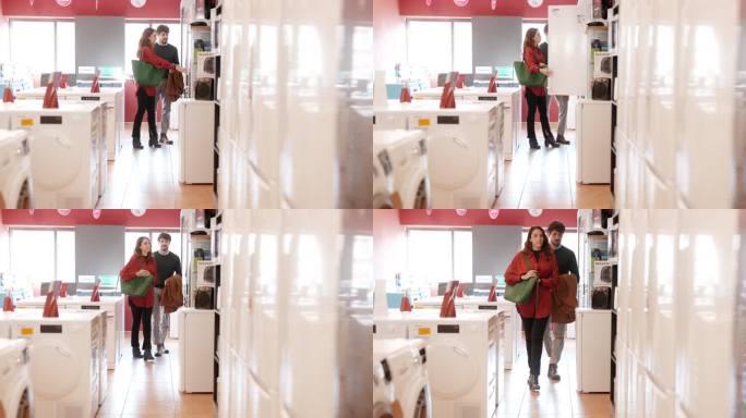 一对夫妇在一家电子商店挑选了一台冰箱。
