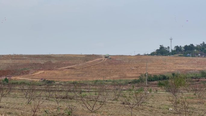 郊区土坡远景运输渣土的卡车