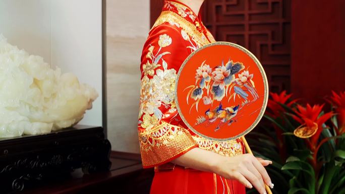 中式秀禾服的新娘拿着圆扇