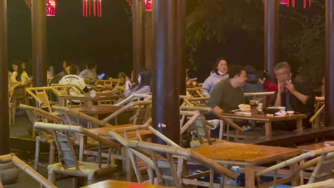 夜晚公园竹编椅喝盖碗茶的人们