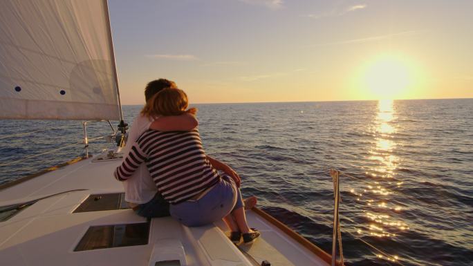 SLO MO情侣在夕阳下享受帆船