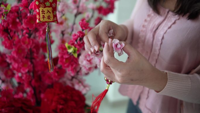 亚洲中国微笑的妇女在樱花上装饰中国新年饰品