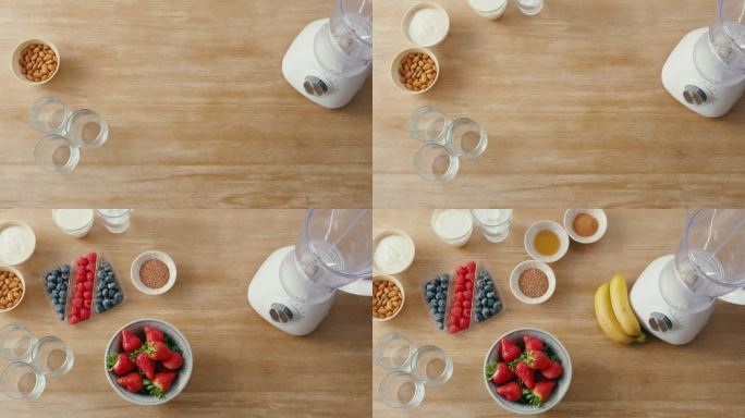 上图是新鲜水果和健康早餐冰沙搅拌机。草莓、蓝莓、覆盆子、苹果、坚果和酸奶放在空荡荡的厨房里。准备准备