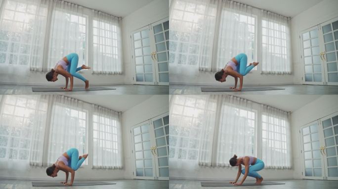擅长瑜伽，亚洲女性在家做乌鸦式。