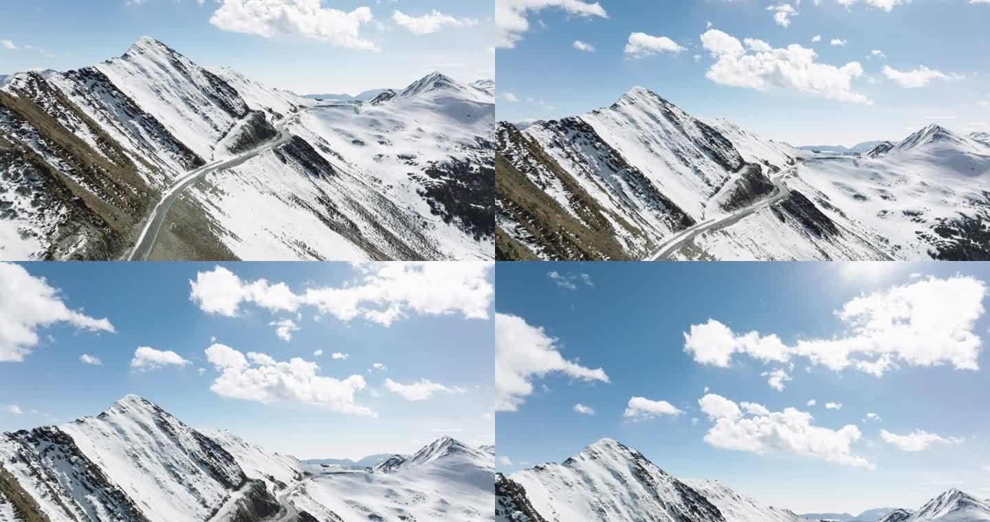 镜头上升航拍夹金山冬季雪景蓝天白云山路