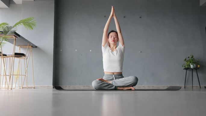 年轻女子练习瑜伽瑜伽外国人打坐冥想健康生