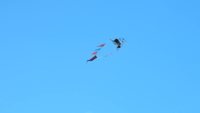 蓝天背景中一只迎风飘动的风筝