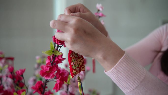 亚洲中国微笑的妇女在樱花上装饰中国新年饰品