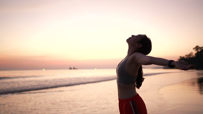 亚洲女性在沙滩上户外练习瑜伽