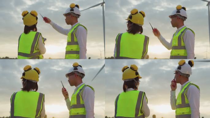 与无人机合作的工程师在风力发电场检查风车，绿色能源概念。