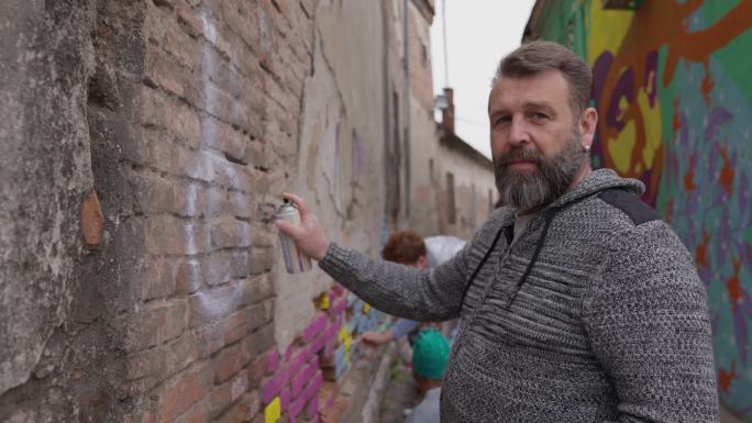 男性艺术家的肖像，呈现绘制城市壁画的社区