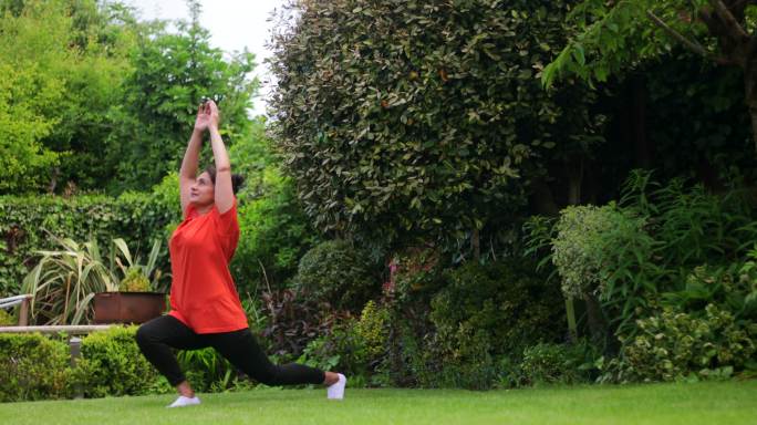 在花园里做瑜伽公园做瑜伽女性伸展大腿