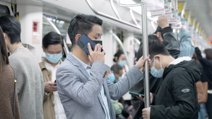 都市男士在地铁车厢手机打电话接电话