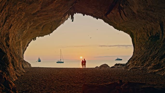 意大利撒丁岛卡拉卢纳海滩一对情侣的慢镜头照片。